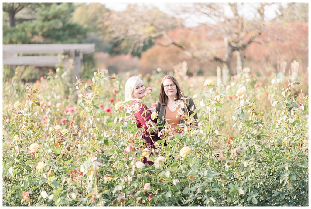 a female couple in the middle of a flower garden 