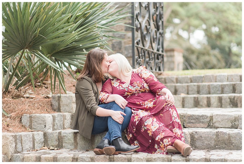 a couple kisses on the steps at norfolk botanical gardens 